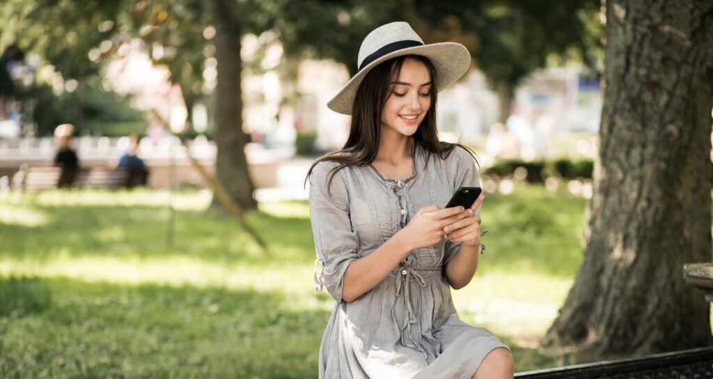 A woman sitting down and using her phone